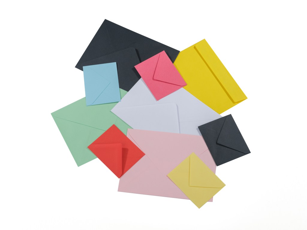 Various colored envelopes laid out, being used by real estate investor to stand out from other direct mail campaigns. 